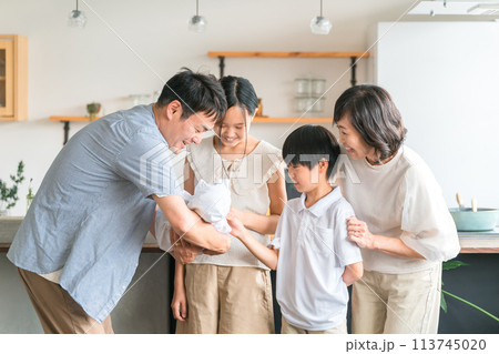 赤ちゃんを娘と息子に見せる・お披露目するパパと家族・ファミリー 113745020
