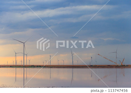Building and assembling a construction wind turbines farm by a crane 113747456