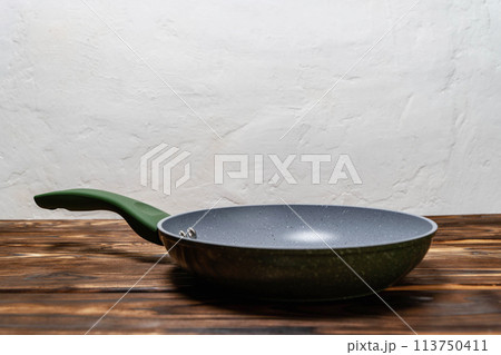 Frying Pan on Wooden Table. ready for cooking or serving food Frying Pan on Wooden Table. ready for cooking or serving food 113750411