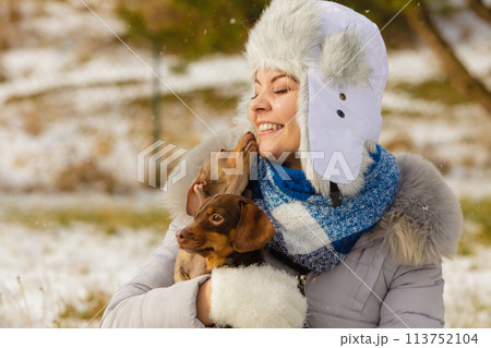 Woman playing with dogs during winter Woman playing with dogs during winter 113752104