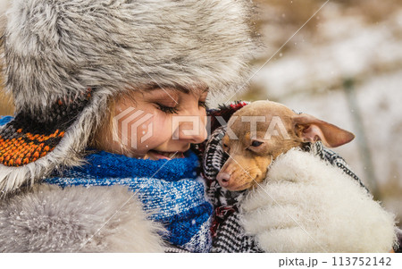 Woman hug warming her little dog in winter 113752142
