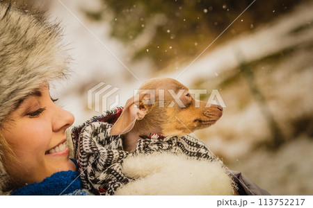 Woman hug warming her little dog in winter Woman hug warming her little dog in winter 113752217
