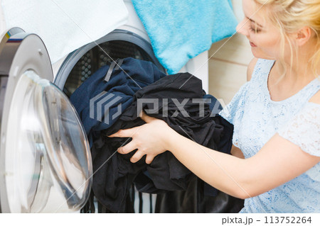 Woman washing black color laundry Woman washing black color laundry 113752264