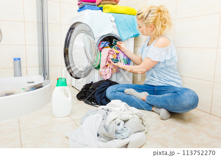 Woman wash laundry using detergent pods 113752270
