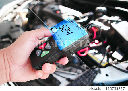 Car technician checking CCA Cold Cranking Amp of car battery with battery tester Car technician checking CCA Cold Cranking Amp of car battery with battery tester 113753257
