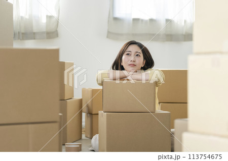 引越しイメージ　荷造りをする若い女性　 113754675