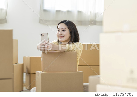 引越しイメージ　スマートフォンを持った若い女性　 113754706