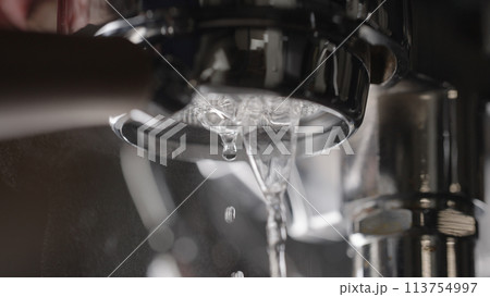 rinsing coffee machine with bottomless portafilter closeup 113754997
