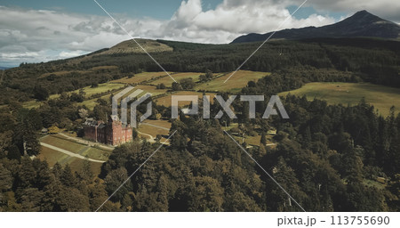 Scotland mountains, old castle aerial panning shot: designed landscapes of garden and parks near building. Beautiful woods, hills, valleys in horizon at summer day. Dramatic scenery view 113755690