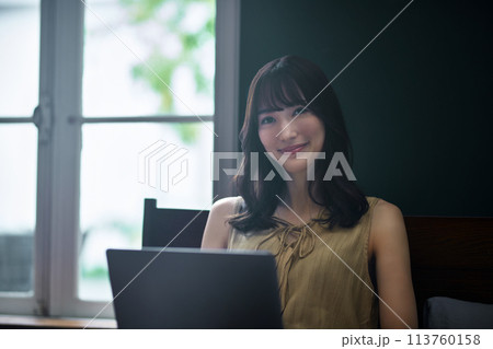 寝室でパソコンを操作する若い女性 113760158