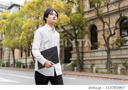 文書ファイルを持って歩く男性 文書ファイルを持って歩く男性 113760967