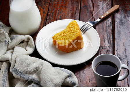 Corn Cake With Coconut white plate on rustic wooden table. Typical Brazilian party food. Corn Cake With Coconut white plate on rustic wooden table. Typical Brazilian party food. 113762930