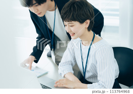 オフイスでパソコン操作をする若い男女 オフイスでパソコン操作をする若い男女 113764968