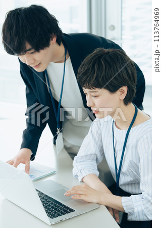 オフイスでパソコン操作をする若い男女 113764969