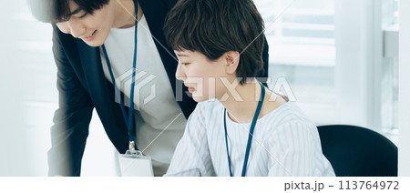 オフイスでパソコン操作をする若い男女 113764972