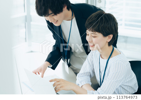 オフイスでパソコン操作をする若い男女 113764973