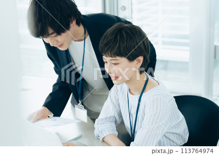 オフイスでパソコン操作をする若い男女 113764974
