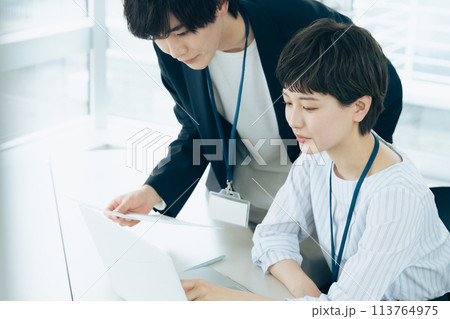 オフイスでパソコン操作をする若い男女 113764975