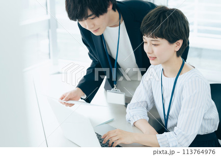 オフイスでパソコン操作をする若い男女 113764976