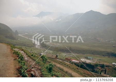 A misty view of Lao Cai Village in a valley with a river flowing through, surrounded by mountains. Sa pa, Vietnam 113769208