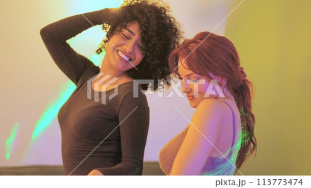 Sensual women dancing together in a home party Sensual women dancing together in a home party 113773474