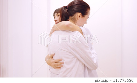 Doctor crying receives a hug and support from her coworker 113773556