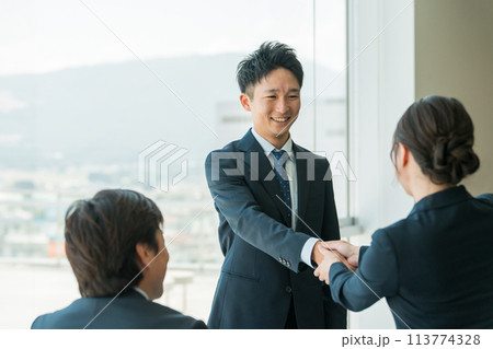 企業のオフィス・会議室で握手をして挨拶・自己紹介・契約を結ぶビジネスマン 113774328