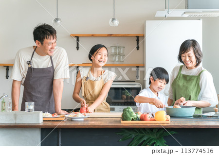 家のキッチンで子供と一緒に料理・クッキング・お手伝いする子供と夫婦・親子・家族 113774516