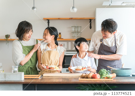 家のキッチンで子供と一緒に料理・クッキング・お手伝いする子供と夫婦・親子・家族 113774521