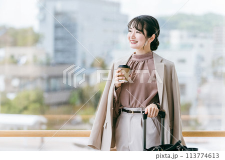 駅・ターミナルのエントランスでコーヒーを飲むビジネスウーマン(待ち合わせ・デート・待つ・温まる) 駅・ターミナルのエントランスでコーヒーを飲むビジネスウーマン(待ち合わせ・デート・待つ・温まる) 113774613