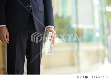 ビジネスイメージ ペットボトルを持つスーツ姿の若い男性 ビジネスイメージ ペットボトルを持つスーツ姿の若い男性 113776409