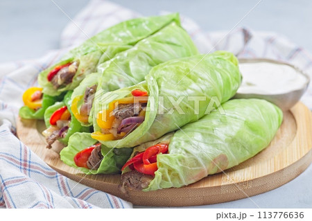Cabbage leaves wraps with beef, vegetables and cheese, served with plain yogurt, horizontal Cabbage leaves wraps with beef, vegetables and cheese, served with plain yogurt, horizontal 113776636