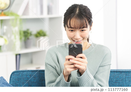 スマートフォンでゲームをする女性 113777160