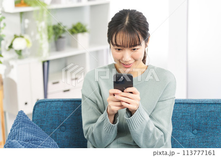 スマートフォンでゲームをする女性 スマートフォンでゲームをする女性 113777161