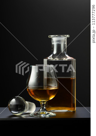 Old decanter and glass with whiskey, cognac or brandy. 113777296