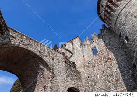 Angular view of Brescia castle with stone arch and tower 113777547
