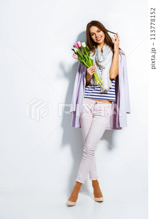 Fashion photo of beautiful woman with tulips in her hand. March 8. beautiful girl in stylish clothes Fashion photo of beautiful woman with tulips in her hand. March 8. beautiful girl in stylish clothes 113778152