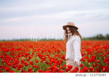 Young woman walking in amazing poppy field. Nature, vacation, relax and lifestyle. Young woman walking in amazing poppy field. Nature, vacation, relax and lifestyle. 113778365