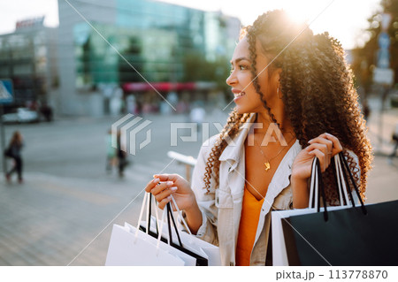 Young woman with shopping bags walking on street. , Sale concept. Young woman with shopping bags walking on street. , Sale concept. 113778870