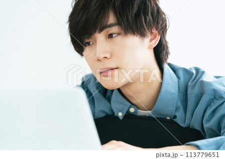パソコンを見てぼんやりする若い男性 113779651