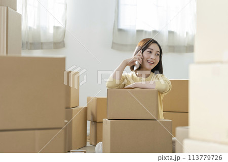 引越しイメージ　スマートフォンで通話する若い女性　 113779726