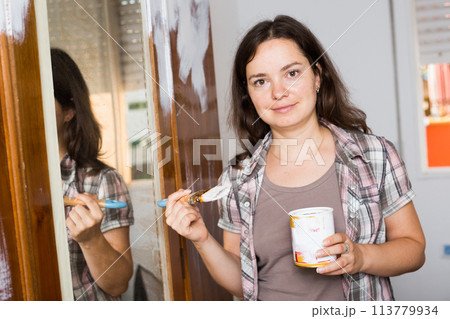 Woman is painting old cupboard in time repairs Woman is painting old cupboard in time repairs 113779934