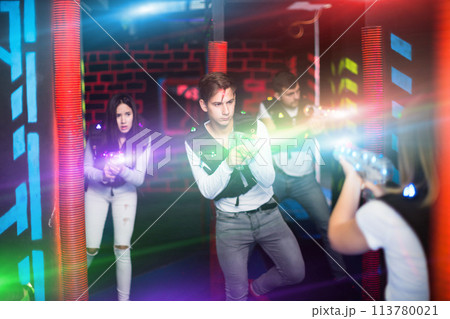 Excited guy laser tag player in bright beams 113780021