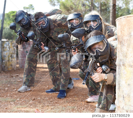Paintball players aiming with guns Paintball players aiming with guns 113780029