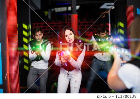 Girl playing laser tag in colorful beams Girl playing laser tag in colorful beams 113780139