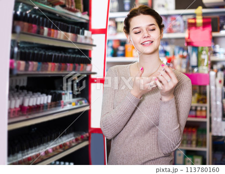 female customer looking for lipstick in cosmetics shop female customer looking for lipstick in cosmetics shop 113780160