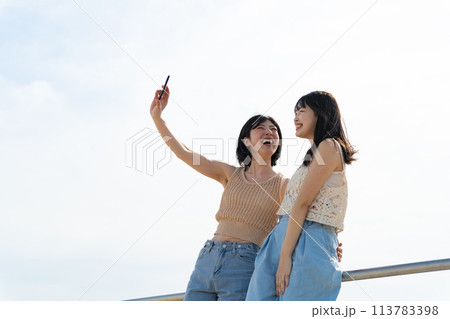 浜辺で遊ぶ女性2人 113783398