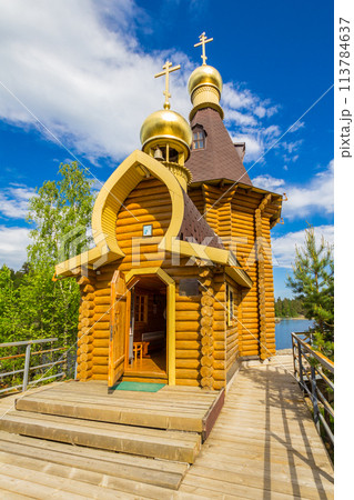 beautiful view to wooden Church of St. Apostle Andrew First-Called on Vuoksa River with bridge. Temple on small island near village Vasilevo, Melnikovo, Priozersky District Leningrad region. Russia 113784637