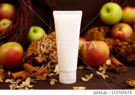 cosmetic moisturizer cream in white tube bottle, apples, cinnamon, dried flowers on brown. Body cream, gel, skincare, hand creme, shampoo, hair conditioner or packaging mockup in autumn composition. cosmetic moisturizer cream in white tube bottle, apples, cinnamon, dried flowers on brown. Body cream, gel, skincare, hand creme, shampoo, hair conditioner or packaging mockup in autumn composition. 113785678