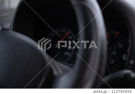 steering wheel and speedometer in the cockpit of a simple car 113785858